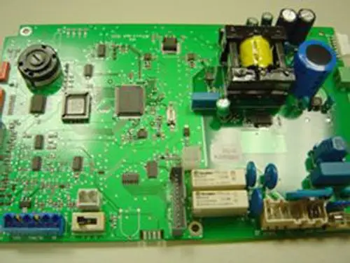 Grüne elektronische Leiterplatte mit verschiedenen Bauteilen, darunter ein Transformator und Kondensatoren, hergestellt von Remeha.